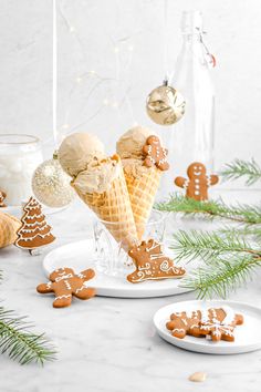 gingerbread ice cream cones decorated with ginger cookies and christmas decorations on a marble table