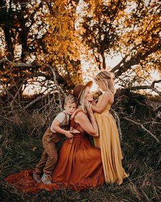 a mother and her son are sitting in the grass with their arms around each other