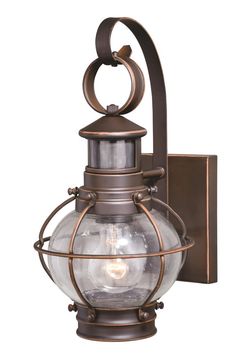 an old fashioned wall light with a glass globe on the top and metal frame around it