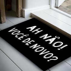 a black door mat with white writing on it