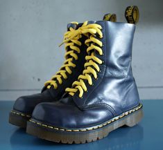 a pair of blue boots with yellow laces on them