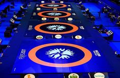 rows of blue and orange floor mats with logos on them in an arena or convention hall