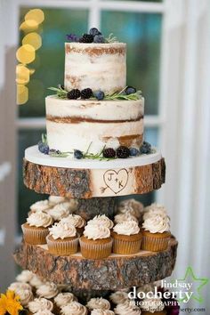 a three tiered cake sitting on top of a tree stump