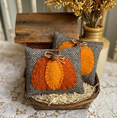 two decorative pumpkin pillows sitting on top of a table