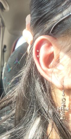 a woman with ear piercings in the back seat of a car