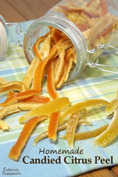 some orange peels are on a table next to a jar with something in it