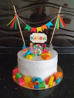 a birthday cake with legos on top and decorations around the edges that spell out kavra