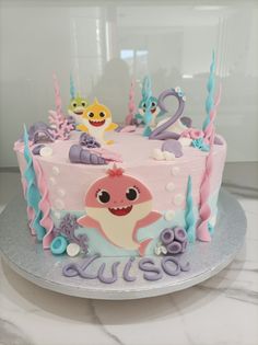 a birthday cake decorated to look like a baby shark and other sea creatures on a plate