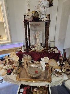 a table topped with lots of assorted items and a busturine on top of it