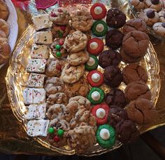 a platter filled with lots of different types of cookies and pastries on top of a table