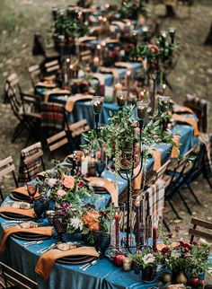 an image of a table set up with blue and white linens, greenery and candles