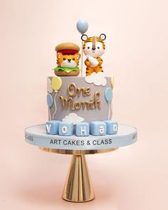 a one month birthday cake with teddy bears on top