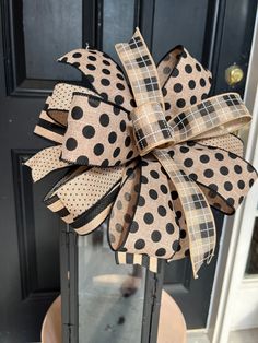 a black and white polka dot bow sitting on top of a metal stand in front of a door