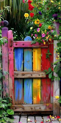 a colorful wooden fence with flowers growing over it