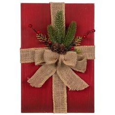 a christmas present wrapped in burlock with pine cones and berries tied to it