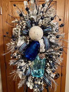 a blue and white christmas wreath on a door