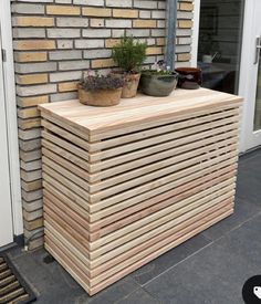 a wooden planter sitting on top of a pile of wood next to a door