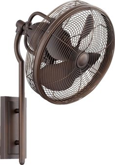 a wall mounted fan on the side of a metal pole next to a light fixture