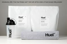 two coffee bags, one white and one black with the word huel on it