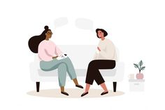 two women sitting on a couch talking to each other, one is holding a cat