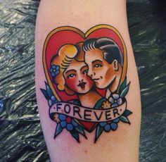 a tattoo with an image of two people in a heart and the words forever on it