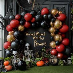 a decorated halloween wreath with balloons and skeleton figurines in front of it that says,