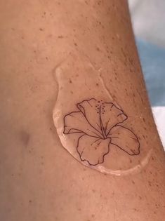 a woman's arm with a tattoo on it that has a flower in the center