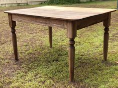 a wooden table sitting on top of a grass covered field