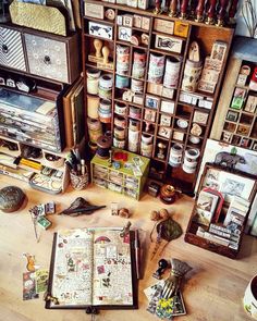 an open book sitting on top of a wooden table next to many other books and knick - knacks