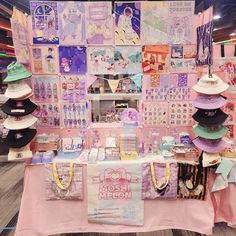 a table with many hats on top of it in front of a wall covered in pictures