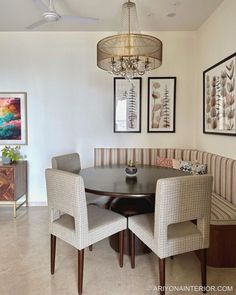 a dinning room table with four chairs and a chandelier hanging from the ceiling