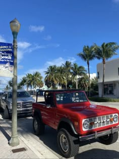 a red pick up truck parked next to a street light