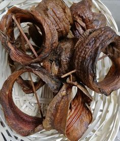 a white basket filled with meat on top of a table