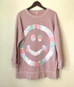 a pink shirt with a smiley face on it