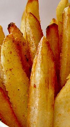 the french fries are seasoned and ready to be eaten with seasoning in a white bowl