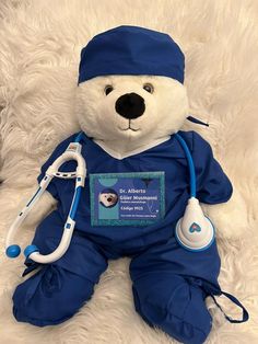 a teddy bear dressed in blue with a stethoscope on it's chest