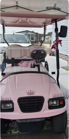 a pink golf cart parked in front of a house