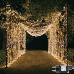 an archway covered in fairy lights at night