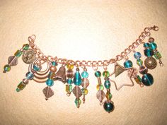 a close up of a bracelet with charms and beads hanging from it's sides