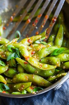 green beans with sesame seeds and seasoning in a silver bowl