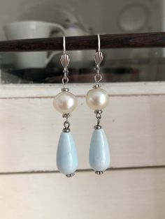 Like all my creations, these earrings were made with care. Very pretty earrings made up of a round mother-of-pearl pearl, a sky blue porcelain drop pearl and small silver pearls. They are light and easy to wear. These pretty earrings will be sent to you quickly in a gift bag. I have lots of pretty jewelry at very affordable prices in my shop: https://rosethalie.etsy.com Do not hesitate to contact me if you would like a particular piece of jewelry or if you have any questions. You can follow me o Affordable Round Bead Pearl Earrings, Elegant Beaded Earrings With Pearl Charm For Gift, Turquoise Pearl Drop Earrings, Elegant Turquoise Pearl Drop Earrings, Handmade Turquoise Dangle Pearl Earrings, Turquoise Teardrop Pearl Drop Earrings, Silver Beaded Pearl Drop Earrings As Gift, Handmade Adjustable Pearl White Earrings, Handmade Mother Of Pearl Teardrop Earrings