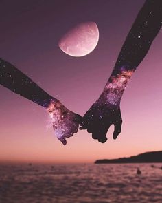 two hands holding each other with the moon in the sky above them and water below