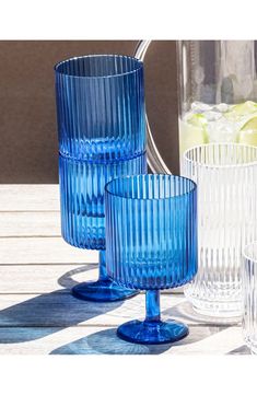 three blue glass vases sitting next to each other on a wooden table with ice