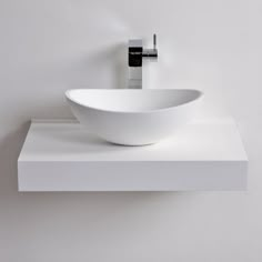 a white bowl sink sitting on top of a counter next to a faucet