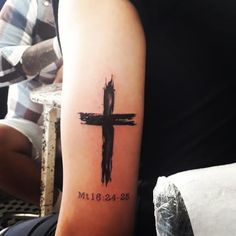 a person with a cross tattoo on their arm