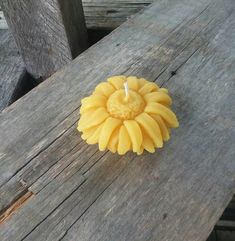 a candle that is sitting on top of a wooden table next to some wood planks