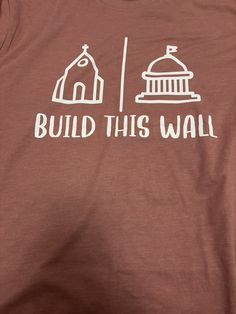 a t - shirt that says build this wall with a building and flag on it