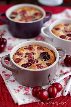 cherry cobbler with fresh cherries on the side and two servings next to it