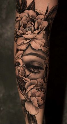 a woman's face with flowers and leaves on her leg, in black and white