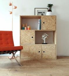 an orange chair sitting in front of a book shelf